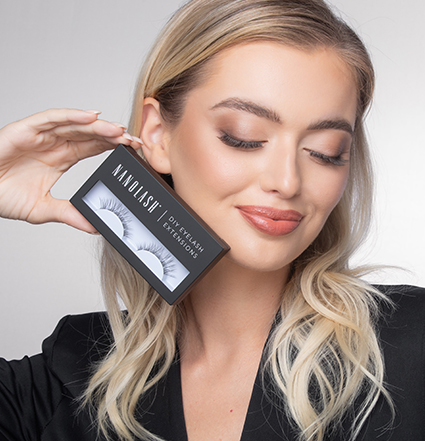 Blonde woman holding eyelash extension kits