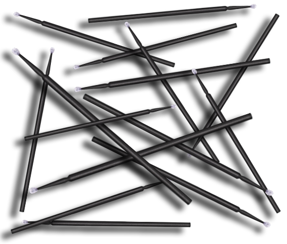 Black microbrush applicators with white tips scattered on dark background