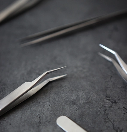 A close up of eyelash tweezers